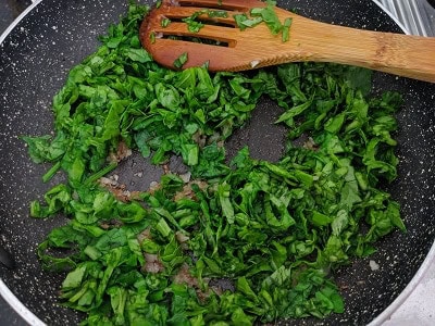 Finely chopped spinach leaves added to onions