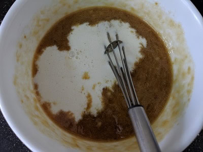 Adding milk and vanilla essence to the jaggery and mashed bananas