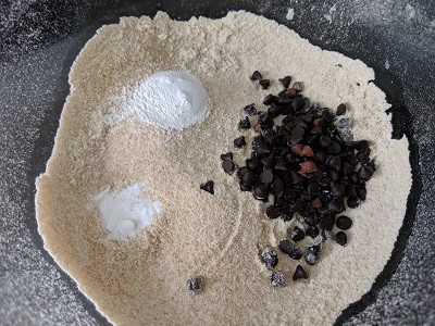 Dry Ingredients for the banana chocolate chip muffins - wheat flour, chocolate chips, baking soda and powder.