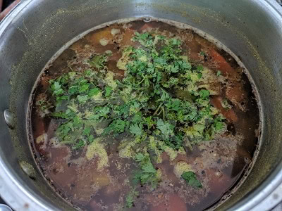 Finely chopped coriander leaves added to rasam