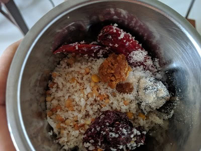 Grinding the ingredients with tamarind and jaggery into a coarse paste