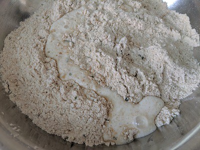 Adding the yeast mixture to the flour and herbs
