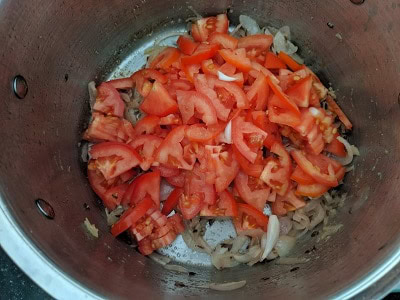 Sliced tomatoes added to the onions