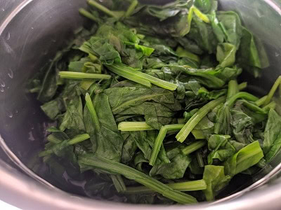 Grinding the cooked spinach leaves