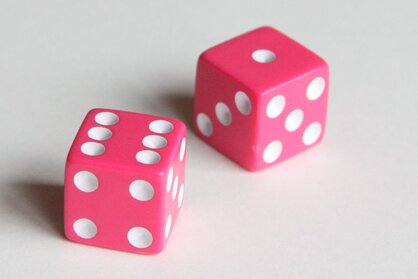 Photo of two pink dice that can be used for many different math games for kids.