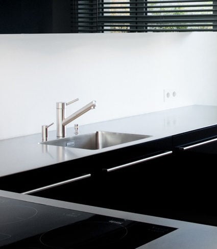 Küche mit schwarzen Glasfronten vom Schreiner