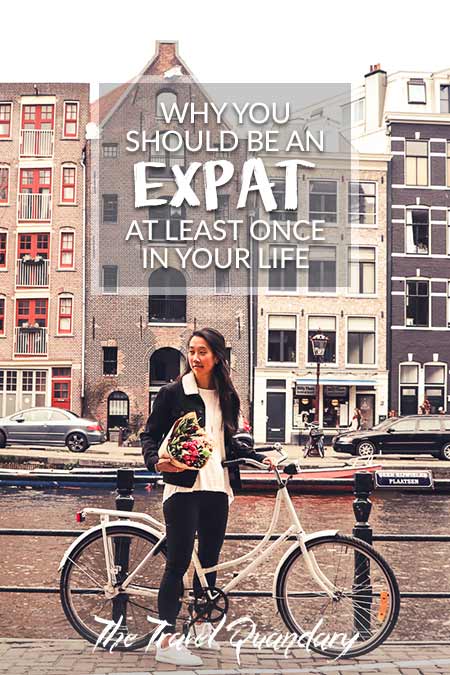 Why You Should Be An Expat At Least Once In Your Life2 A girl stands next to her bicycle holding a bunch of tulips on a canal in Amsterdam, The Netherlands