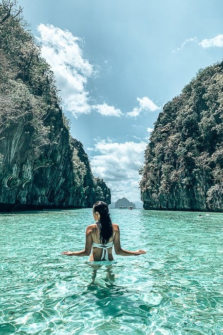 Island Hopping in the Philippines Which boat tour should I choose 6 P A woman wades through the turquoise water at the entrance of Big Lagoon, El Nido