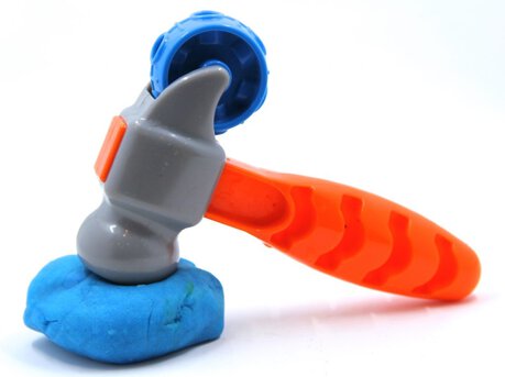 Photo of a toy hammer pounding play dough.