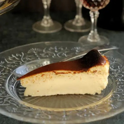 a slice of san sebastian cheesecake on a glass plate