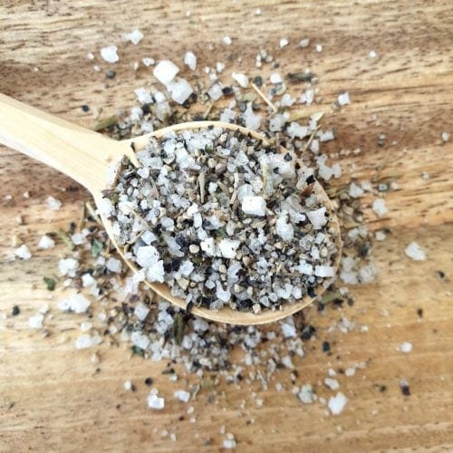 Close up overhead shot of flavoured sea salt spilling out of a wooden spoon.