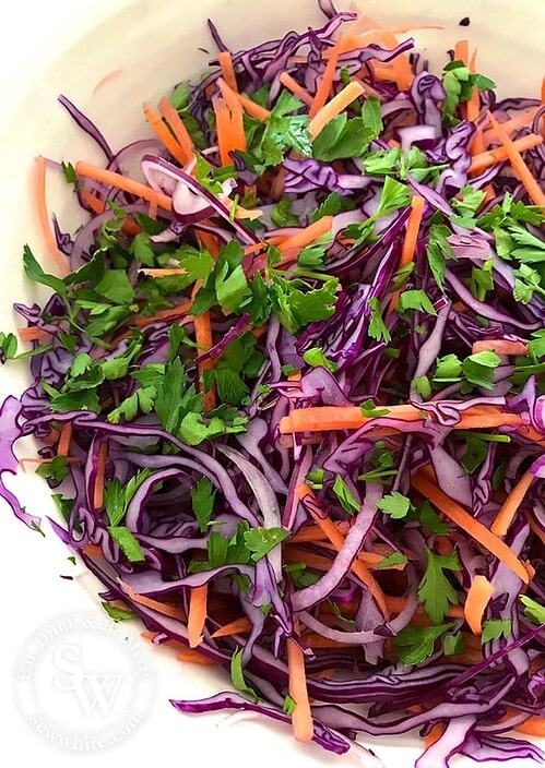 The vibrant fresh colours of the super simple slaw. Rich purple from the red cabbage and onion, orange from the carrot and vibrant green parsley.