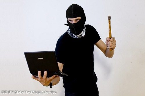 Image of hacker at work with hammer in hand