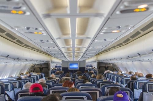 Image of people on an airplane that could use some noise cancelling headphones Image of people on an airplane that could use some noise cancelling headphones