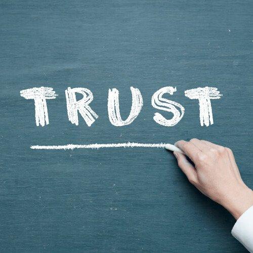 the word trust spelled out on a chalkboard