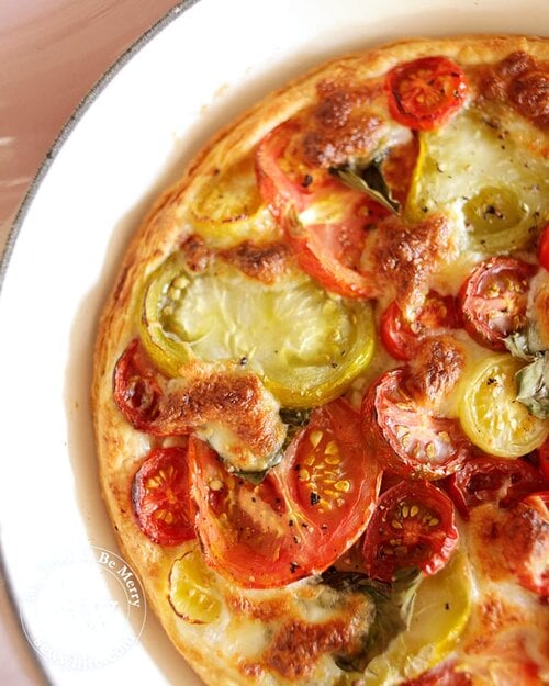 Puff Pastry Tomato Tart with a mix of large and small tomatoes baked with golden brown mozzarella on top.