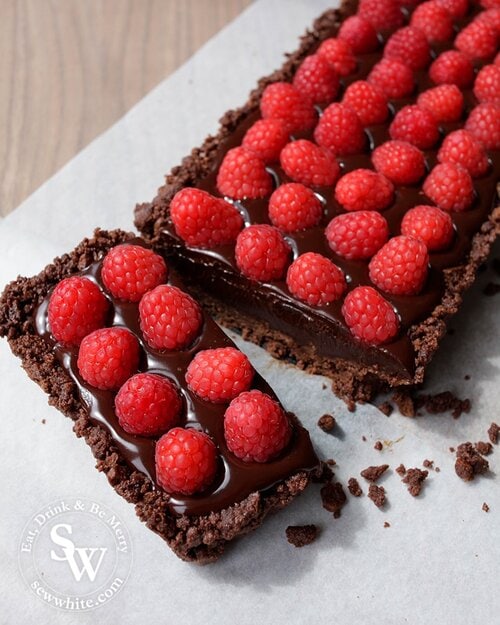 5 ingredient Chocolate Raspberry Tart. A bourbon biscuit base filled with rich chocolate truffle and studded with raspberries.