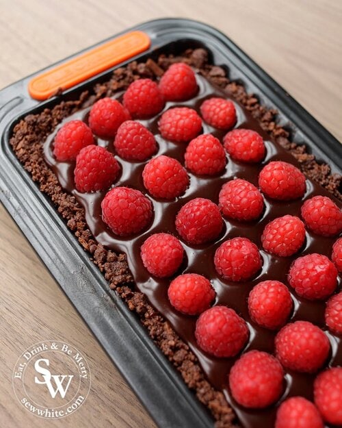 Studded raspberries on a bed chocolate truffle bourbon biscuit base