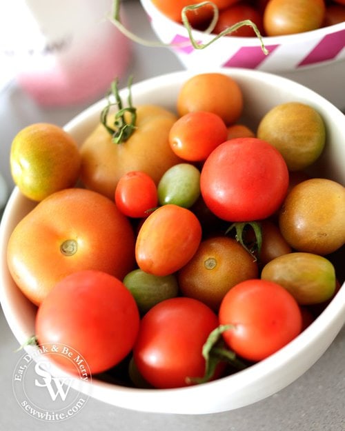 Fresh home grown tomatoes of different sizes in a china bowl.