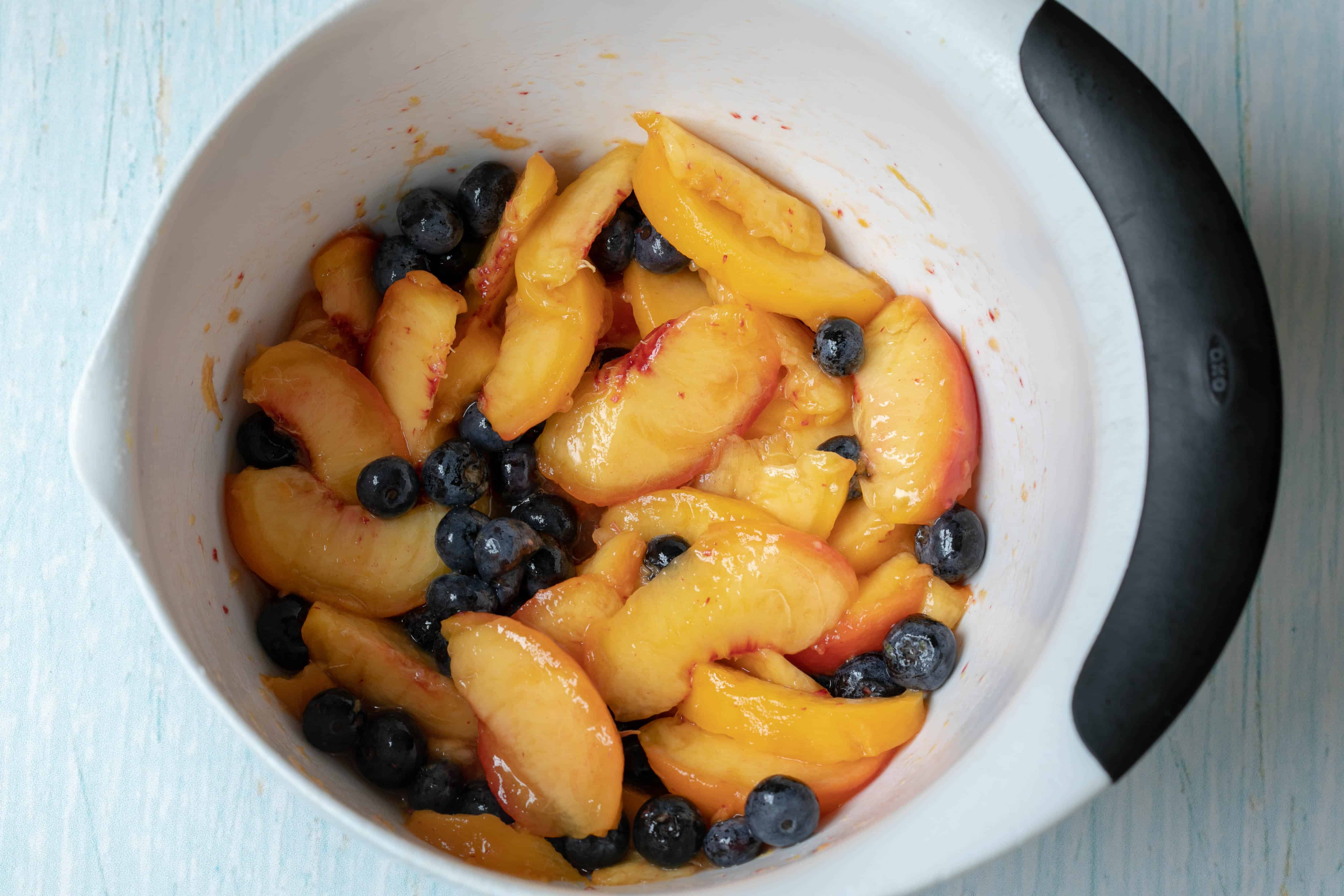 sliced peaches and blueberries in a large bowl
