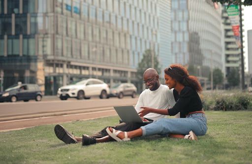 happy international student couple using a laptop