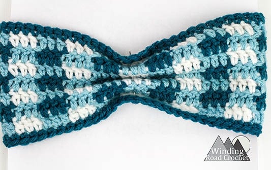 Learn to crochet this easy plaid ear warmer or headband. This crochet project works up fast and makes a great gift. We used them for family photos. Full photo tutorial showing how to make them. It is just one free crochet pattern to make all three styles. #crochet #crochetheadband #crochetearwarmer