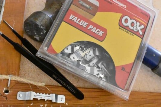 picture hangers, tweezers, and hammer