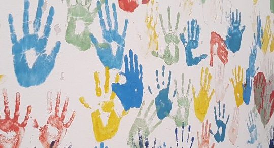 Multi-coloured handprints on a wall