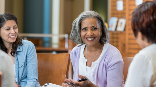 mature educator speaking with other staff members
