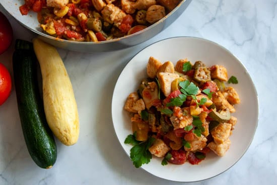 Cajun chicken succotash on white plate on marble