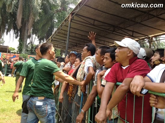 Petugas keamanan menenangkan para peserta yang berteriak-teriak.