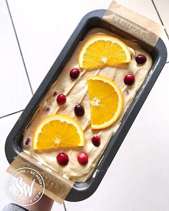 Oven ready orange and cranberry cake ready to be baked in the oven.