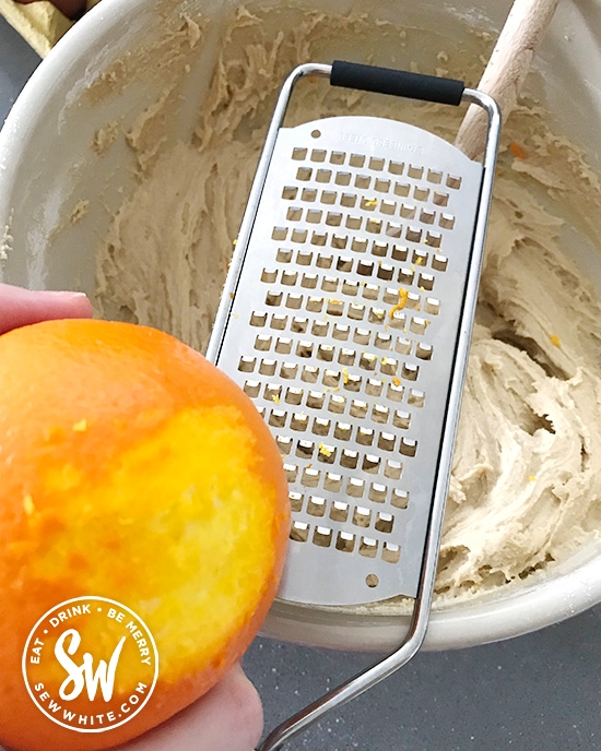 grating orange zest into the cake mix