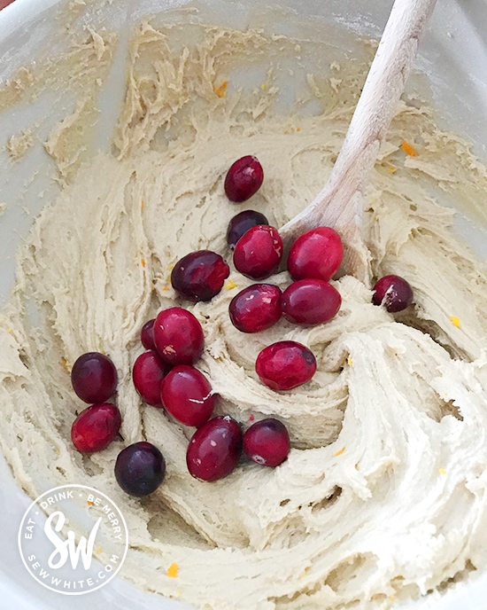 mixing fresh cranberries into the cake mix