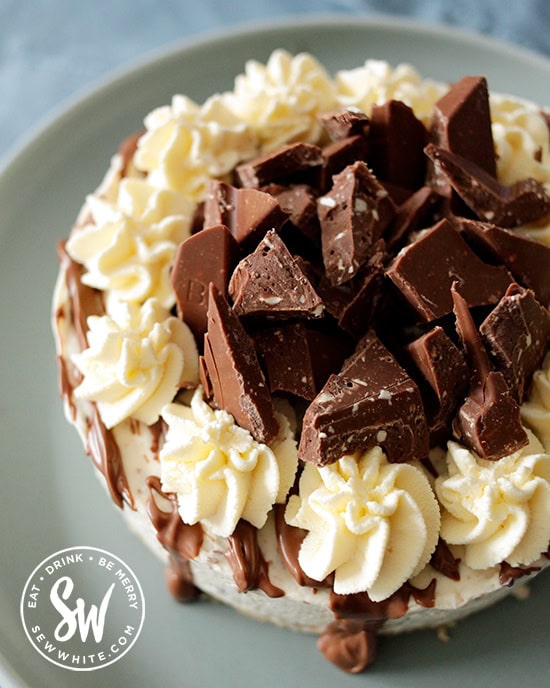 Pieces of Toblerone broken up on the cheesecake with swirls of cream.