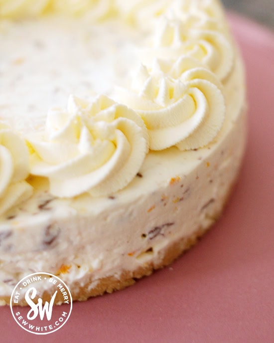 orange zest and chocolate orange chips in the cream cheesecake layer on a shortbread biscuit base with swirls of cream on top