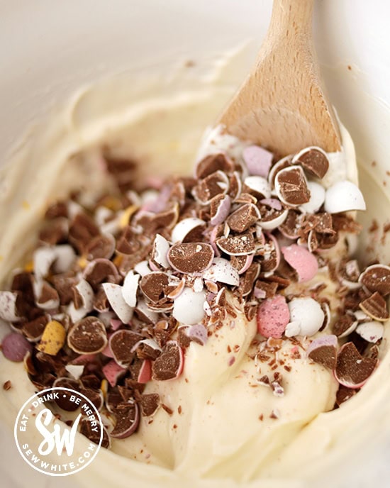 Chopped up mini eggs being mixed in to the cream cheese mix for the cheesecakes.