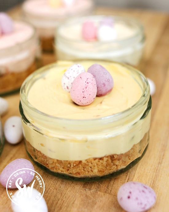 pastel yellow mini egg cheesecake in a glass jar.