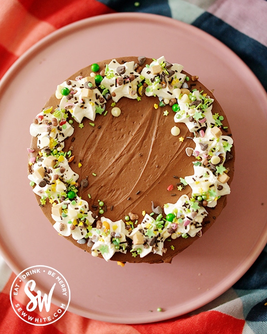 Guinness cheesecake with white cream top decorated with green sprinkles to make it give a hint of Ireland