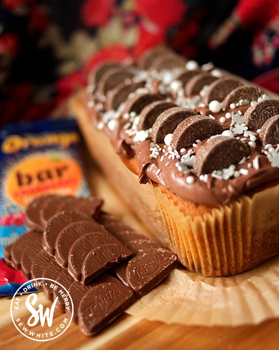Chocolate Cranberry Cake next to a Terry's chocolate orange bar and topped with mini chocolate orange segments