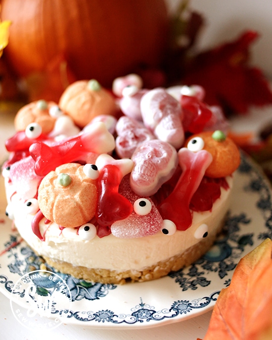 Halloween cheesecake covered with candy and edible eye sprinkles and edible pumpkins marshmallows
