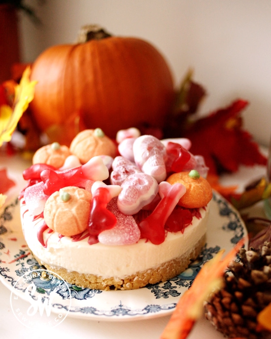 Halloween cheesecake nestled among pumpkins, fall leaves and pinecones