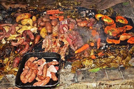 Curanto preparation involves cooking meat and vegetable wrapped in leaves over hot stones