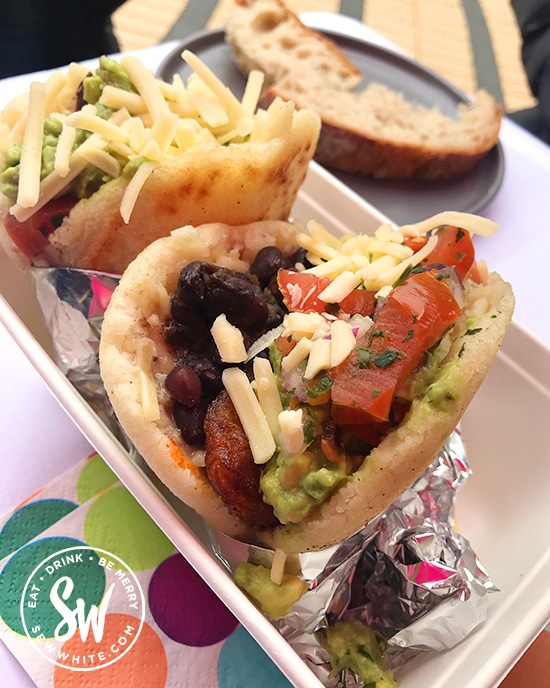 Venezuelan arepa rolls stuffed with tomatoes, beans. cheese and guacamole