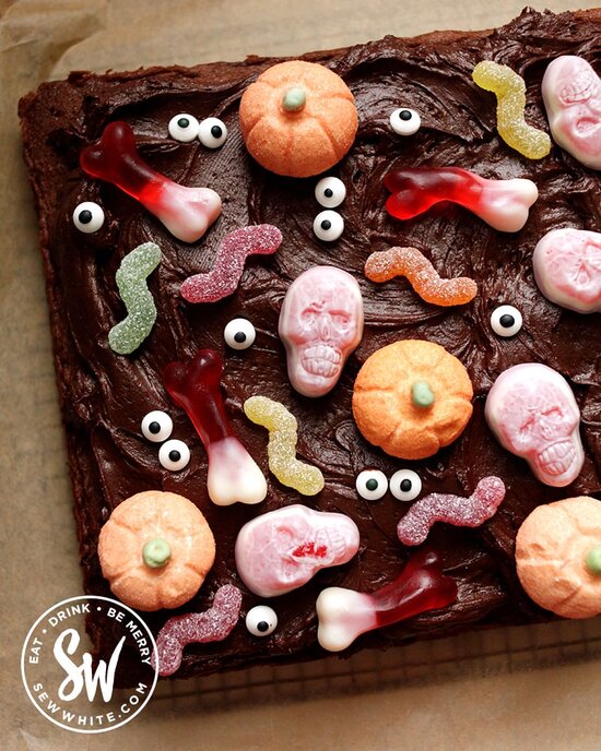 Easy Halloween Chocolate Cake covered with chocolate frosting and decorated with Halloween candy and sweets