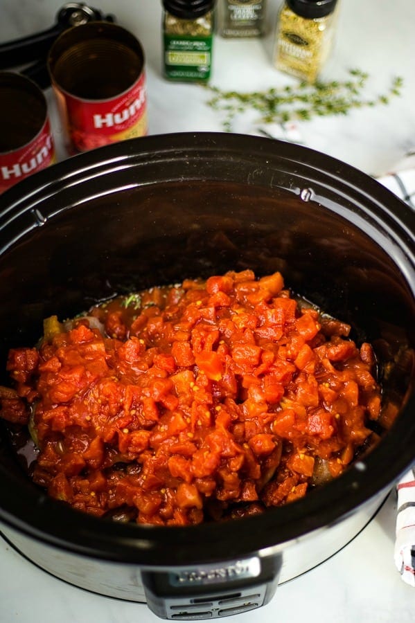 petite diced tomatoes on top of raw chicken in crockpot