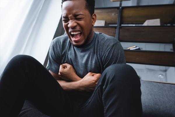 stressed african american man screaming while having panic attac stressed african american man screaming while having panic attack at home