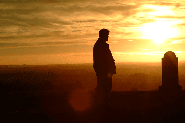 man at grave at dusk