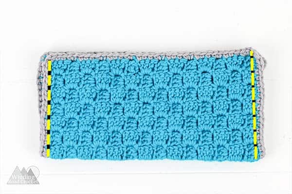 Corner to Corner crochet zipper pouch is a perfect first crochet pattern for beginners that just learned the corner to corner crochet stitch. Check out the accompanying post that has video and photo tutorials for how to corner to corner crochet. This crochet bag can hold pens, hooks, and other supplies. There is a photo tutorial for how to add a no sew liner. #c2ccrochet #crochetbag