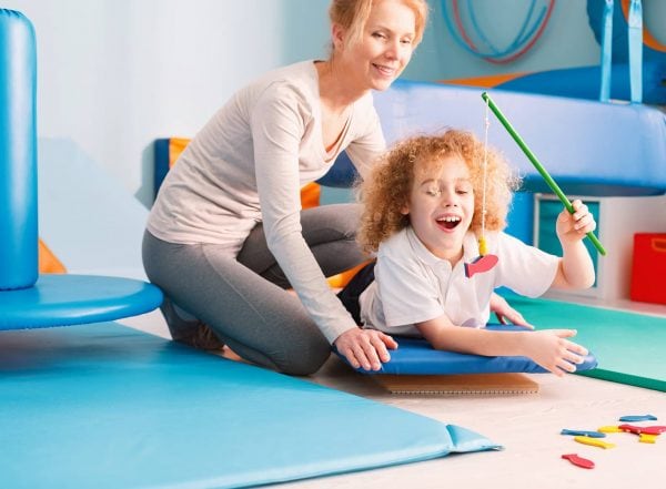 What is a Childrens occupational therapist occupational therapist supporting child on a wobble board